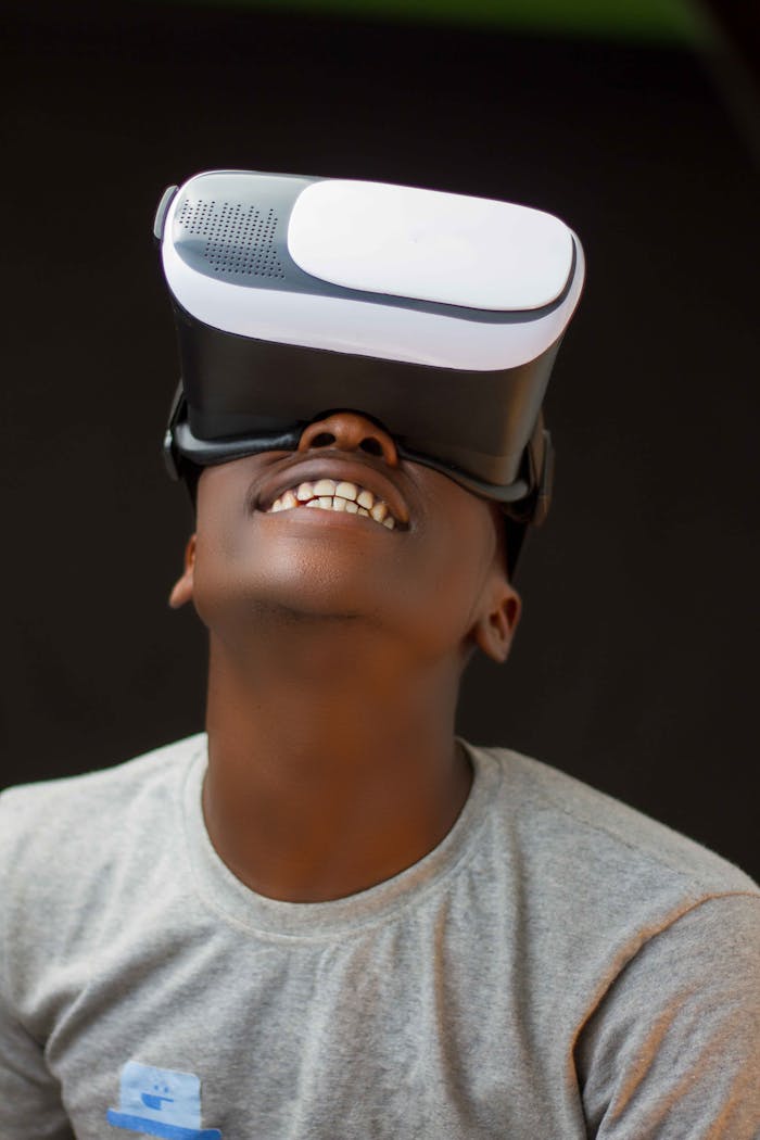 Adult enjoying immersive experience using VR headset, smiling against black background.